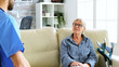 © DC Studio - Senior old woman sitting on couch in nursing home talking with the doctor. Over the shoulder shot