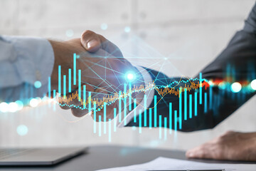 Double exposure of two people handshake congratulate each other with a great deal and financial chart. Success concept.