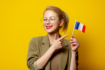 Wall Mural - Style blonde woman in jacket with French flag on yellow background