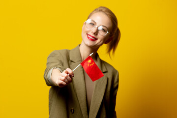 Style blonde woman in jacket with Chinese flag on yellow background