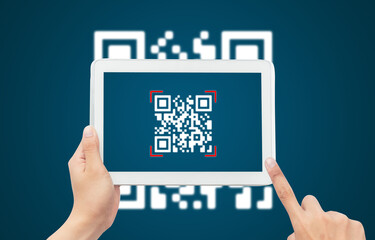 Hand using tablet computer scan Qr code on blue background. Cashless technology and digital money concept.