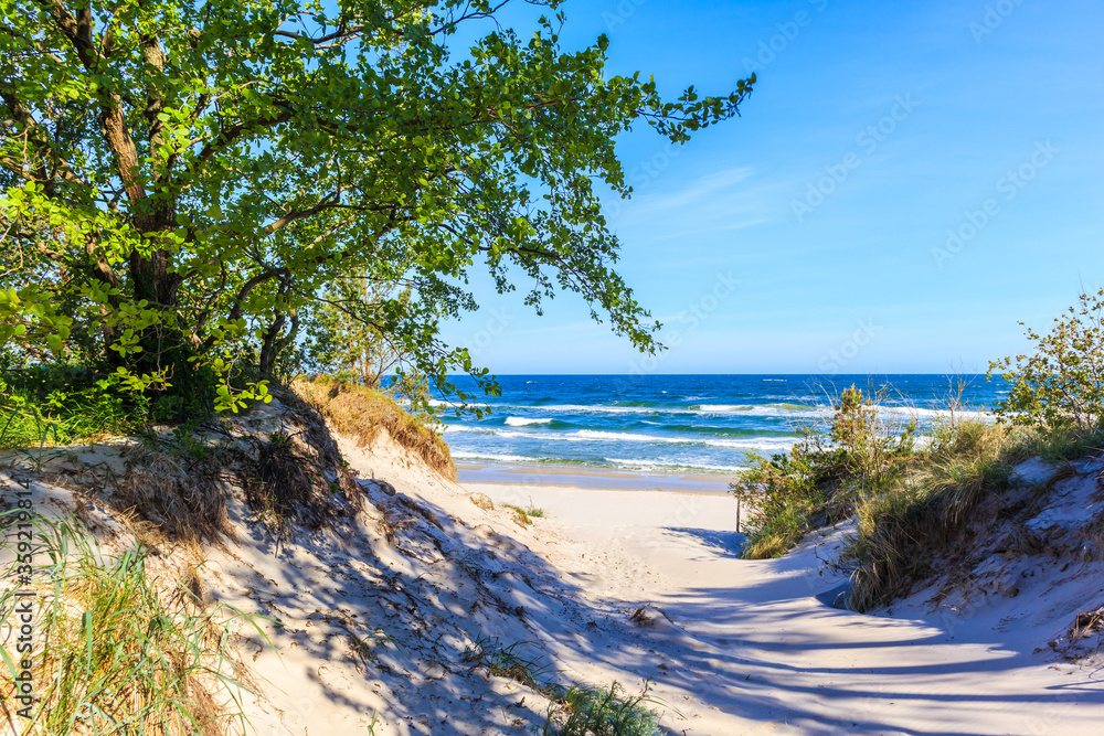 Entrance to beautiful white sand beach with blue sea near Kolobrzeg, Baltic Sea coast, Poland - obrazy, fototapety, plakaty 