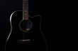 © ARTFULLY-79 - Black acoustic guitar studio shot on black background with copyspace, Guitar is favorite music instrument for hobby.