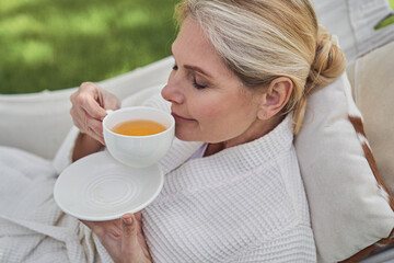 Wall Mural - Serene female having cup of hot drink outdoors