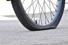 Closeup View Of Bicycle Flat Tire On Pavement.