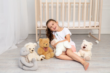 little girl 5-6 years old playing in the children's room with teddy bears