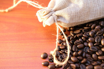 Canvas Print - close up coffee beans and coffee cup on wood table background and texture