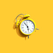 © Tierney - Yellow vintage alarm clock with shadow - flat lay