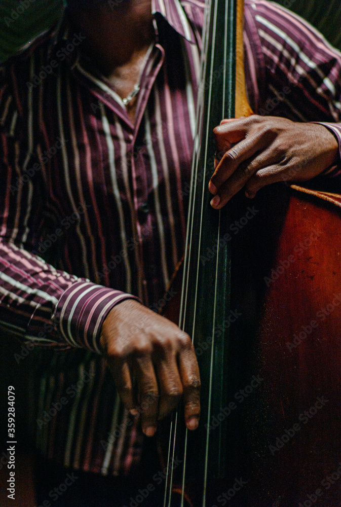 African American jazz musician hands playing upright bass in a dark club. - obrazy, fototapety, plakaty 