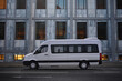 Minibus of corporate transportation of staff in the background of a business center in a business district