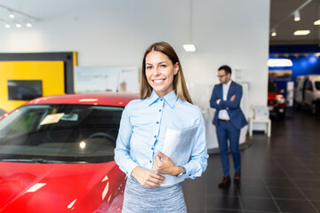 Wall Mural - Beautiful saleswoman standing and posing  at the dealership showroom.