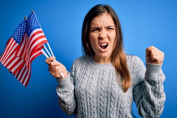 Poster - young patriotic woman holding usa flag on independence day 4th of july over blue background annoyed 