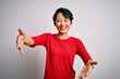 © Krakenimages.com - Young beautiful asian girl wearing casual red t-shirt standing over isolated white background looking at the camera smiling with open arms for hug. Cheerful expression embracing happiness.