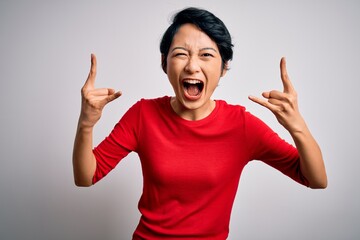 Poster - Young beautiful asian girl wearing casual red t-shirt standing over isolated white background shouting with crazy expression doing rock symbol with hands up. Music star. Heavy music concept.