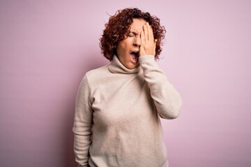 Poster - Middle age beautiful curly hair woman wearing casual turtleneck sweater over pink background Yawning tired covering half face, eye and mouth with hand. Face hurts in pain.