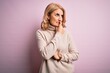 © Krakenimages.com - Middle age beautiful blonde woman wearing casual turtleneck sweater over pink background looking stressed and nervous with hands on mouth biting nails. Anxiety problem.