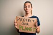 © Krakenimages.com - Young beautiful blonde woman with blue eyes asking for protect planet holding banner scared in shock with a surprise face, afraid and excited with fear expression