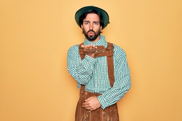 Wall Mural - Young handsome man wearing tratidional german octoberfest custome for Germany festival looking at the camera blowing a kiss with hand on air being lovely and sexy. Love expression.