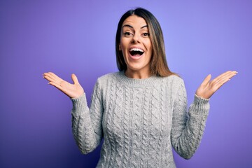 Poster - Young beautiful woman wearing casual sweater standing over isolated purple background celebrating crazy and amazed for success with arms raised and open eyes screaming excited. Winner concept