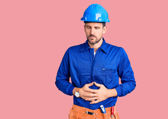 Canvas Print - Young handsome man wearing worker uniform and hardhat touching mouth with hand with painful expression because of toothache or dental illness on teeth. dentist