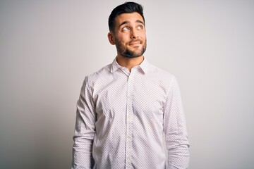 Wall Mural - Young handsome man wearing elegant shirt standing over isolated white background smiling looking to the side and staring away thinking.
