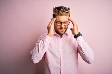 Sticker - Young handsome business man wearing golden crown as king over pink background suffering from headache desperate and stressed because pain and migraine. Hands on head.