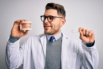 Professional dentist doctor smiling and holding denture with braces and invisible aligner, comparing healthy orthodontics teeth alignment