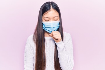 Sticker - Young beautiful chinese woman wearing medical mask feeling unwell and coughing as symptom for cold or bronchitis. health care concept.