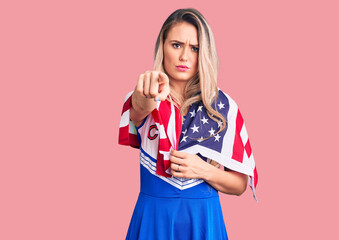 Sticker - Young beautiful blonde woman wearing cheerleader uniform and united states flag pointing with finger to the camera and to you, confident gesture looking serious