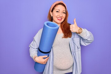 Sticker - Young beautiful redhead pregnant woman expecting baby holding mat to do prenatal exercise happy with big smile doing ok sign, thumb up with fingers, excellent sign