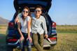 © PK Studio - Young couple happy asian out on a road trip. Asian couple Man  and woman sitting on back of car travel to mountain and lake in holiday with car road trip