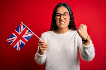 Poster - Young asian woman holding united kingdom flag for brexit referendum over red background annoyed and frustrated shouting with anger, crazy and yelling with raised hand, anger concept