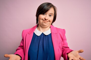 Sticker - Young down syndrome business woman over pink background clueless and confused expression with arms and hands raised. Doubt concept.