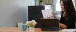 © bongkarn - Female professor online teaching with digital tablet and notebook on wooden worktable in living room