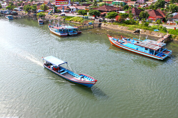 Poster - Colorful blue and red fishing boats in the Batang Arau river and port in Padang City in West Sumatra, Indonesia.