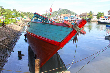 Wall Mural - Colorful blue and red fishing boats in the Batang Arau river and port in Padang City in West Sumatra, Indonesia.