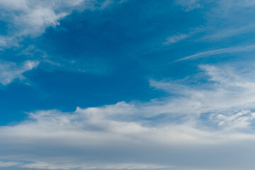 Wall Mural - white clouds stretched across the blue sky on a warm sunny day