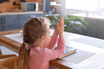 Wall Mural - Little girl with Bible praying at home