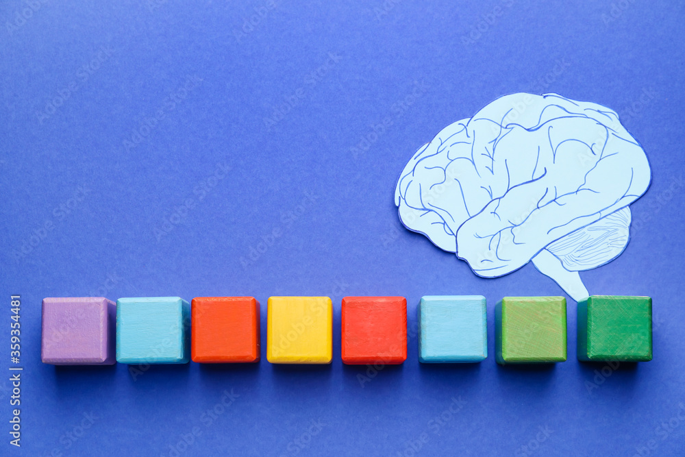 Cubes and paper brain on color background. Dyslexia concept