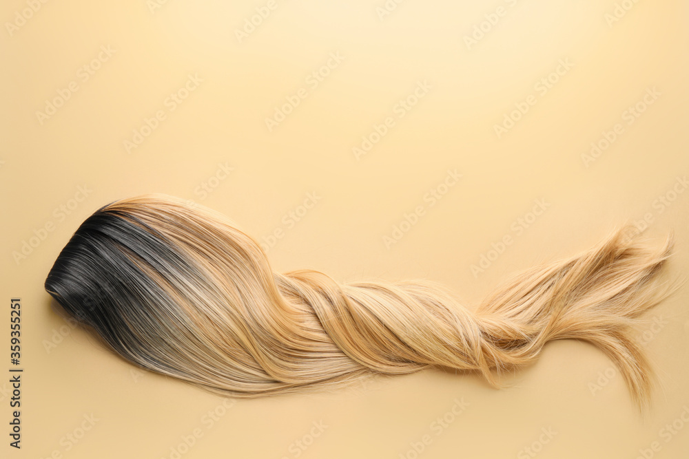 Female wig on color background