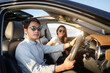 © PK Studio - Young couple in his car, happy to drive on a country road. Happy young women and young men in car