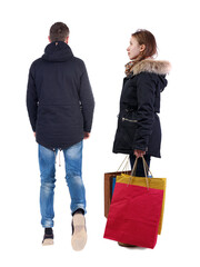 Canvas Print - back view of couple with shopping bags in winter jacket.