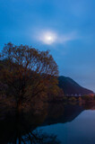 Fototapeta Krajobraz - 夜明けの満月が美しい湖畔