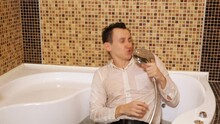 Man In A Shirt And Trousers Sings In A Bath Of Water. Slow Motion.