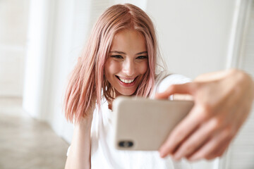 Canvas Print - Photo of caucasian excited woman taking selfie photo on mobile phone