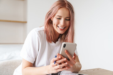 Canvas Print - Image of woman using smartphone while doing homework with exercise books