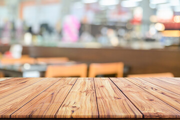 Wall Mural - Wooden table top on blurred background of interior coffee shop or restaurant blur cafe coffee shop background