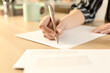© PheelingsMedia - Woman hands writing letter sitting on a desk