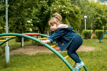 little girl on the playground. happy smiling child playing on outdoor.baby laughs, shouts emotionall