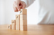 © oatawa - Business concept growth success process, Businesswoman hand arranging wood cube stacking as step stair with arrow up symbol.